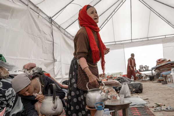 زنان در 13 سپتامبر 2023 در داخل چادری که به عنوان پناهگاه موقت برای بازماندگان زلزله در روستایی در نزدیکی آمزمیز در مرکز مراکش برپا شده است، چای آماده می‌کنند. تیم‌های امداد در 13 سپتامبر تلاش گسترده‌ای را در روستاهای کوهستانی ویران شده مراکش آغاز کردند، زیرا شانس یافتن بازماندگان از بین رفت. از زلزله هفته گذشته که نزدیک به 3000 نفر را کشت و بسیاری را بی خانمان کرد.  - اسپوتنیک افغانستان  