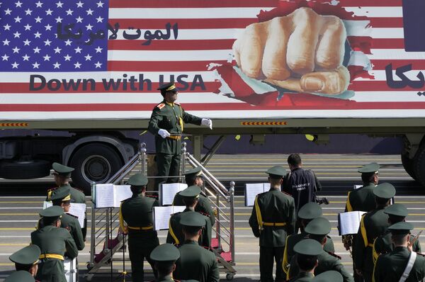 یک بنر ضد آمریکا روی کامیونی در یک رژه نظامی سالانه به مناسبت سالگرد آغاز جنگ علیه ایران توسط صدام حسین، حمل می شود. - اسپوتنیک افغانستان  