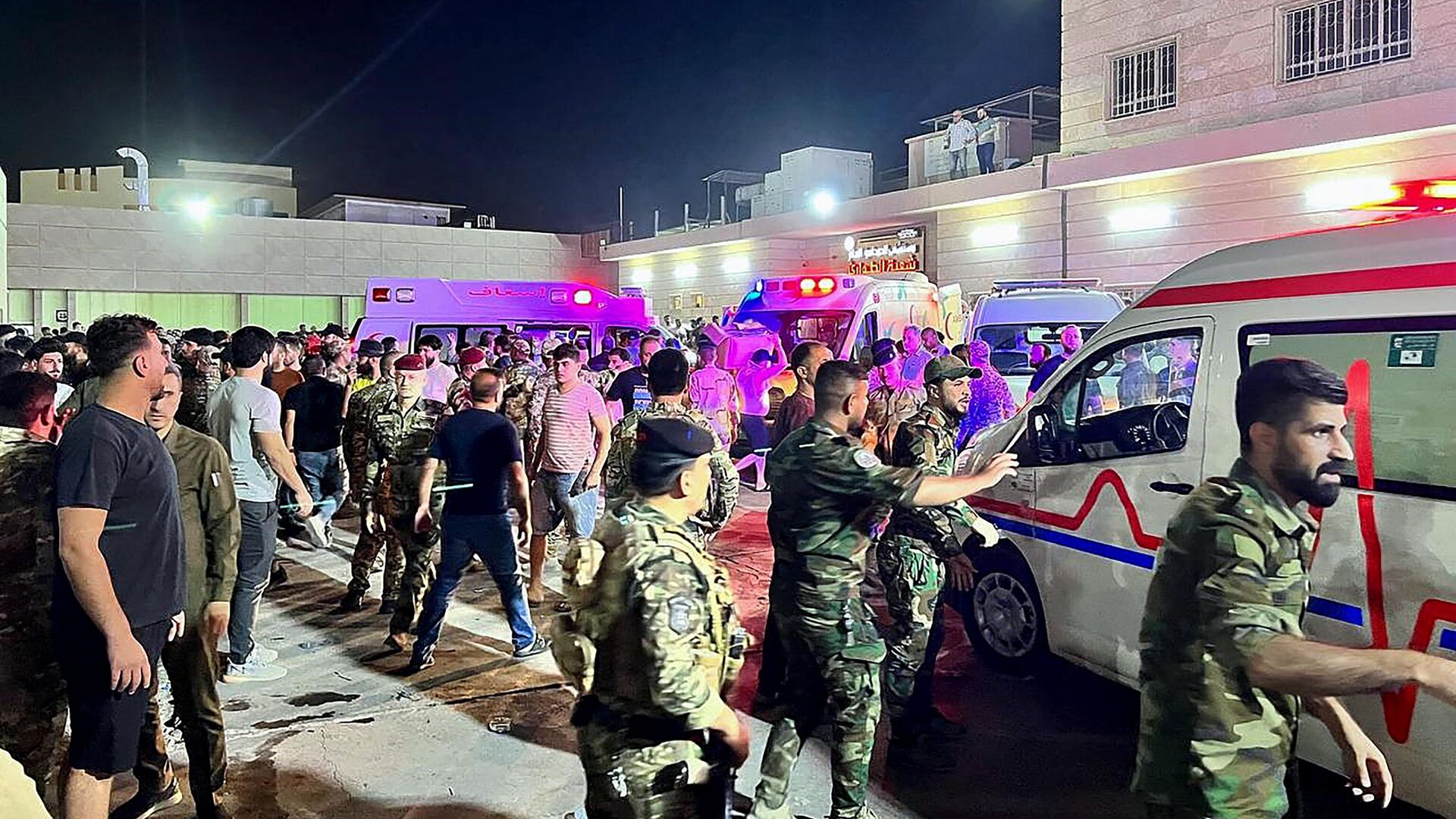 Soldiers and emergency responders gather around ambulances carrying wounded people after a fire broke out during a wedding at an event hall, outside the Hamdaniyah general hospital in Al-Hamdaniyah, Iraq on September 27, 2023. At least 100 people were killed and more than 150 injured when a fire broke out during a wedding at an event hall in the northern Iraqi town of Al-Hamdaniyah, according to state media and health officials, on September 27, 2023.  - اسپوتنیک افغانستان  , 1920, 27.09.2023