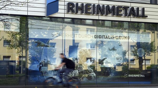 A cyclist rides past the logo of German defence company and automotive supplier Rheinmetall at their headquarters in Duesseldorf, western Germany, on April 21, 2022. - اسپوتنیک افغانستان  