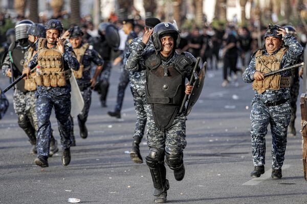 پولیس کنترل شورش معترضانی را که در روز 1 اکتوبر 2023 در چهارمین سالگرد تظاهرات ضد دولتی عراق در سال 2019 در میدان تحریر بغداد تجمع کرده بودند، متفرق می کنند. (عکس از احمد الربیعی / خبرگزاری فرانسه) پولیس کنترل شورش معترضانی را که در روز 1 اکتوبر 2023 در چهارمین سالگرد تظاهرات ضد دولتی عراق در سال 2019 در میدان تحریر بغداد تجمع کرده بودند، متفرق می کنند. (عکس از احمد الربیعی / خبرگزاری فرانسه) - اسپوتنیک افغانستان