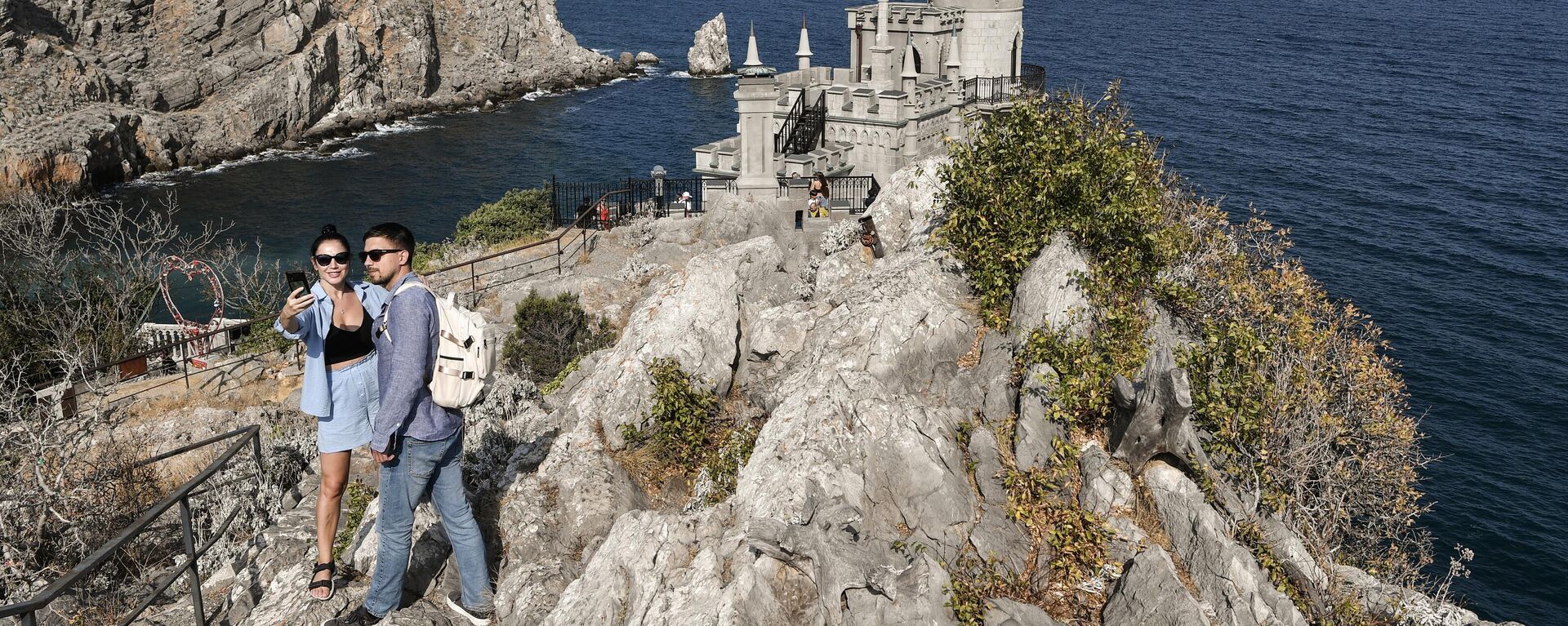 Туристы фотографируются у замка Ласточкино гнездо на береговой скале в поселке Гаспра в Крыму - اسپوتنیک افغانستان  , 1920, 04.05.2024
