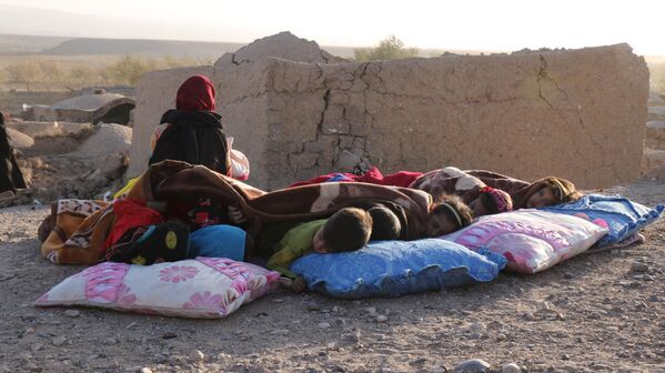 کودکان افغان زیر پتو در کنار خانه های آسیب دیده پس از زلزله در روستای سربلند ولسوالی زنده جان ولایت هرات در 7 اکتبر 2023 استراحت می کنند (عکس از محسن کریمی / خبرگزاری فرانسه) - اسپوتنیک افغانستان  