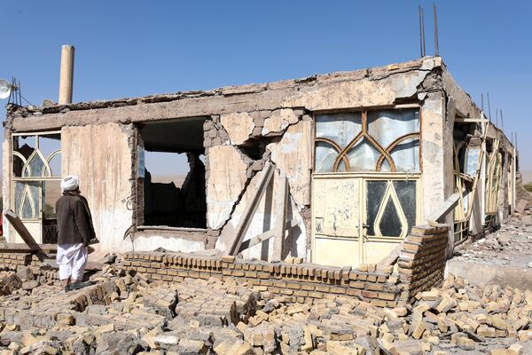 یک مرد افغان در نزدیکی یک خانهتخریب شده پس از زلزله در قریه سربلند ولسوالی زنده جان ولایت هرات در 8 اکتبر 2023 ایستاده است.تعداد تلفات یک زمین لرزه در غرب افغانستان در روز 8 اکتبر دوباره به شدت افزایش یافت و به بیش از 2000 نفر رسید و نزدیک به 10000 زخمی شدند، زیرا نیروهای امداد در دهات ویران شده برای جستجوی علائم حیات حفاری کردند.به گفته مقامات، بیش از 1300 خانه در اثر زمین لرزه 6.3 ریشتری - به دنبال هشت پس لرزه قوی - مناطق صعب العبور را در 30 کیلومتری شمال غرب مرکز ولایت هرات، ویران کردند. - اسپوتنیک افغانستان  