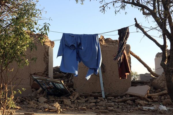 یک ریسمان برای هموار کردن لبای در بین ویرانه های بجا مانده از زلزله. - اسپوتنیک افغانستان  