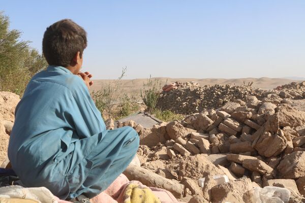 کودکی به ویرانه های بجای مانده از زلزله چشم دوخته است - اسپوتنیک افغانستان  