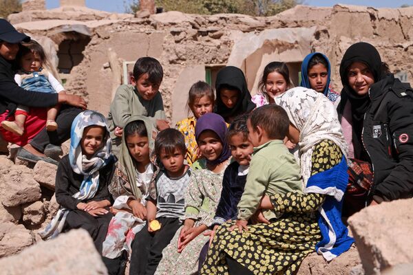 کودکان افغان پس از زلزله در روستای وردخه ولسوالی زنده جان ولایت هرات در نزدیکی خانه های آسیب دیده خود در 10 اکتبر 2023 نشسته اند. - اسپوتنیک افغانستان  