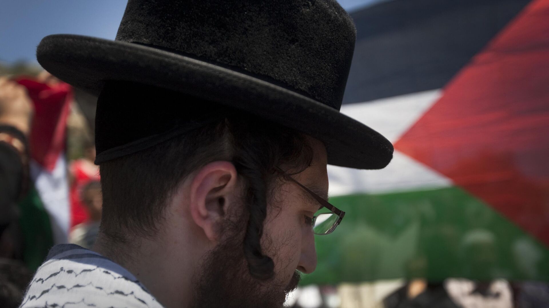 A Palestinian flag flutter in the background as a member of Neturei Karta attends a protest with Palestinian youths in the Arab east Jerusalem neighbourhood of Silwan. File photo. - اسپوتنیک افغانستان  , 1920, 14.10.2023