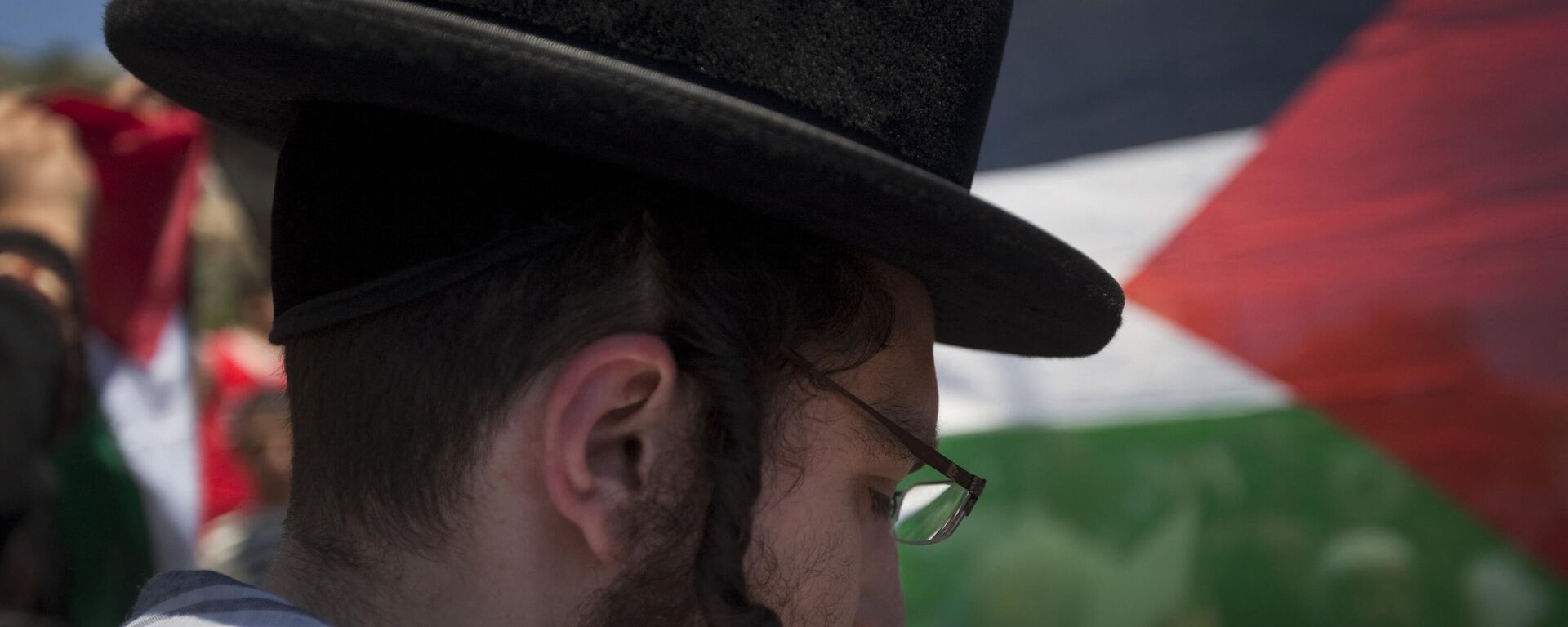 A Palestinian flag flutter in the background as a member of Neturei Karta attends a protest with Palestinian youths in the Arab east Jerusalem neighbourhood of Silwan. File photo. - اسپوتنیک افغانستان  , 1920, 14.10.2023