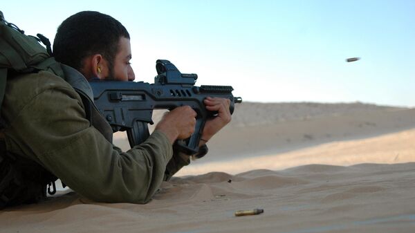 An Israeli soldier fires a TAR-21 weapon, which stands for Tavor Assault Rifle - 21st Century at a military shooting range in southern Israel on July 6, 2009. - اسپوتنیک افغانستان  