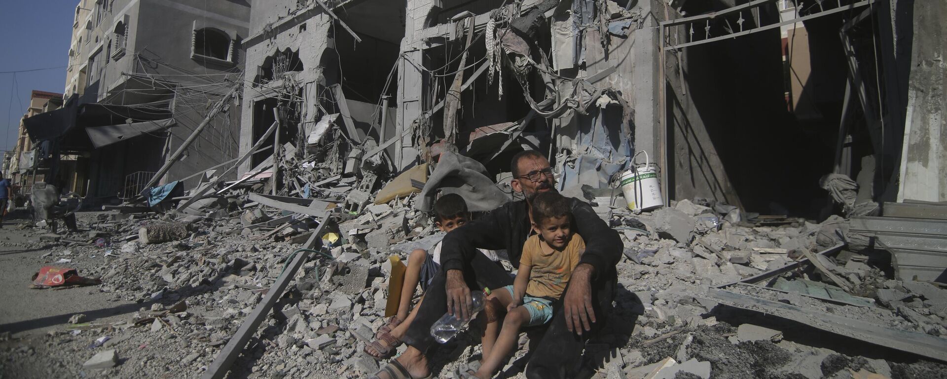 Палестинцы сидят возле своего дома после израильских авиаударов в лагере беженцев Рафах на юге сектора Газа, 12 октября 2023 года - اسپوتنیک افغانستان  , 1920, 15.10.2023