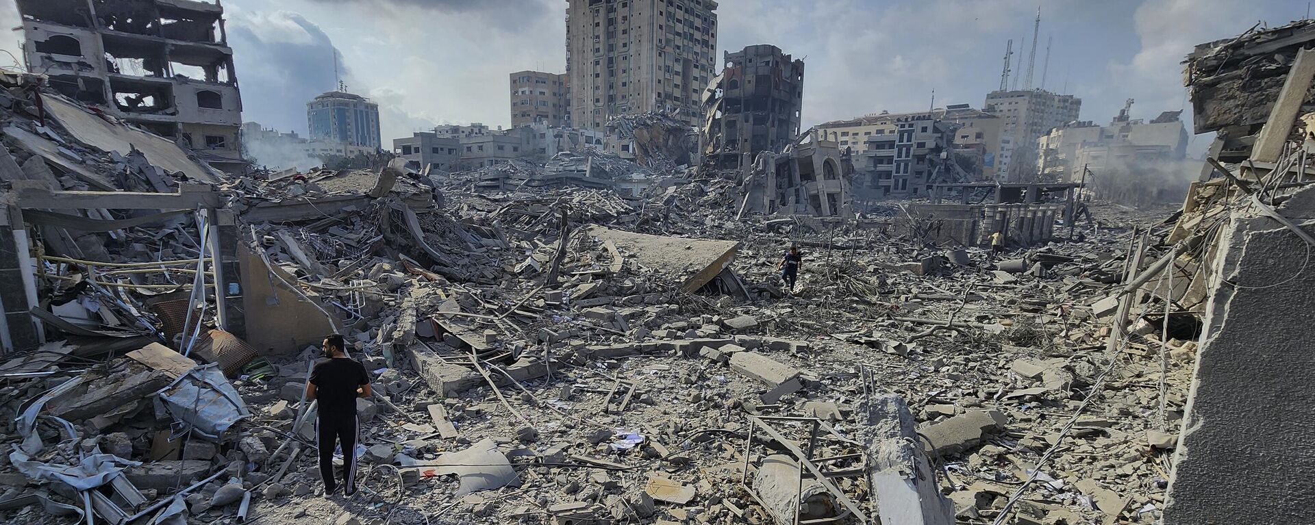 Палестинцы идут через обломки зданий, разрушенных в результате израильских авиаударов в городе Газа, 10 октября 2023 года - اسپوتنیک افغانستان  , 1920, 17.10.2023