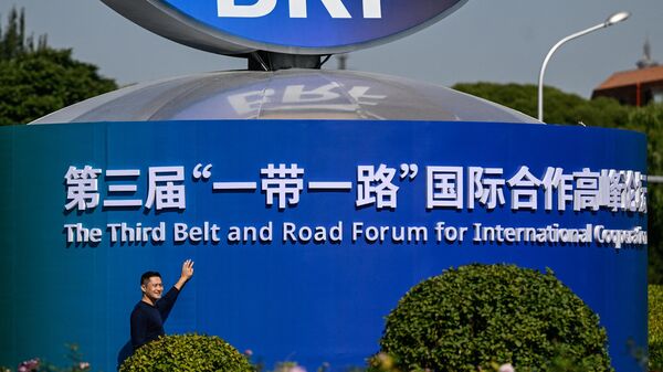 Мужчина позирует рядом с инсталляцией форума Один пояс - один путь в Пекине, Китай - اسپوتنیک افغانستان  