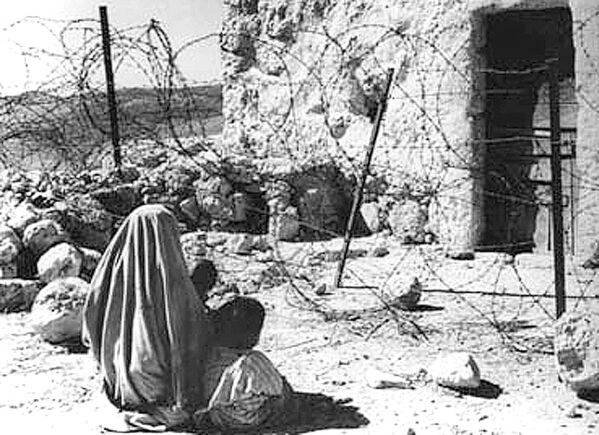 این تصویر مربوط به سال 1948 یک زن پناهنده فلسطینی و فرزندش را نشان می دهد که پس از جنگ 1948 توسط &quot;خط سبز&quot; از خانه خود جدا شده اند. - اسپوتنیک افغانستان  