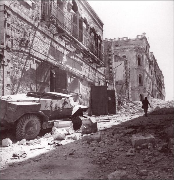 یک موتر زرهی ساخت بریتانیا در میان آوار ساختمان های ویران شده در مرکز شهر اورشلیم رها شده است. 7 جولای 1948 در طول اولین درگیری یهودی-عربی که در فبروری 1948 قبل از اعلام دولت اسرائیل در 14 می 1948 آغاز شد. - اسپوتنیک افغانستان  
