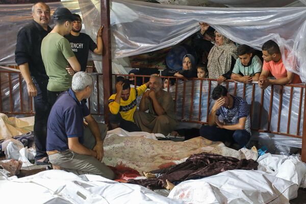 سوگواری بستگان فلسطینی هایی که در حمله به درمانگاه الاهلی در مرکز غزه کشته شدند. - اسپوتنیک افغانستان  