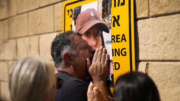 Эли Албаг плачет у фотографии своей дочери Лири во время акции протеста с требованием освободить израильтян, которые были похищены во время нападения ХАМАСа на прошлой неделе в Тель-Авиве, Израиль - اسپوتنیک افغانستان  