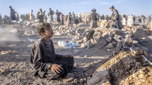Афганский мальчик скорбит рядом с могилой своего младшего брата, погибшего в результате землетрясения в провинции Герат на западе Афганистана - اسپوتنیک افغانستان  