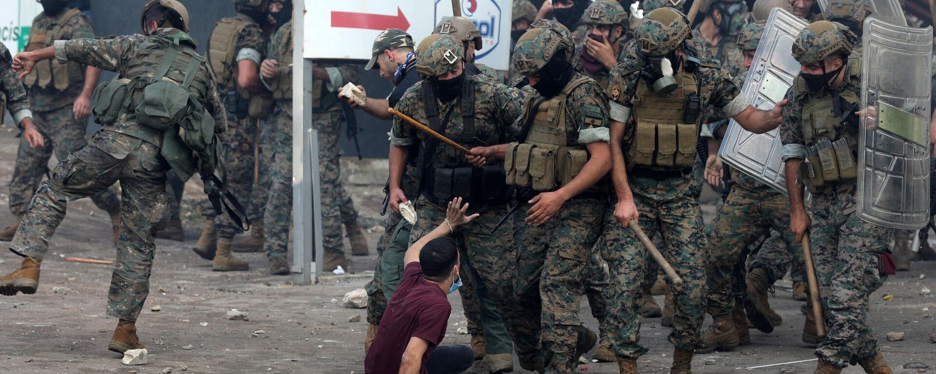 Силы безопасности Ливана угрожают молодому человеку дубинками во время столкновения с протестующими возле посольства США в Аукаре к востоку от Бейрута - اسپوتنیک افغانستان  , 1920, 21.10.2023