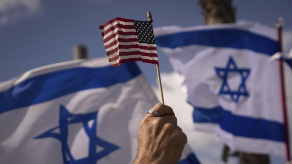 Протестующий размахивает национальными флагами США и Израиля. Архивное фото - اسپوتنیک افغانستان  