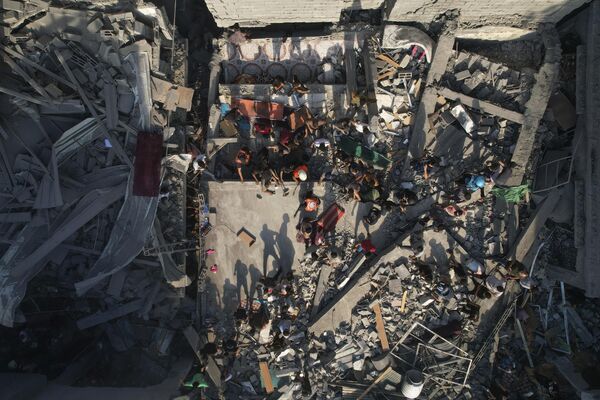 فلسطینی‌ها از آوار ساختمان‌های حمله هوایی اسرائیل به اردوگاه آوارگان الشطی جستجو می‌کنند.اقدامات تلافی جویانه اسرائیل پس از آن تشدید شده است که حماس 7 اکتبر روز شنبه حمله بی سابقه ای را به اسرائیل انجام دادند و بیش از 1200 اسرائیلی را کشتند و ده ها نفر را اسیر کردند. - اسپوتنیک افغانستان  