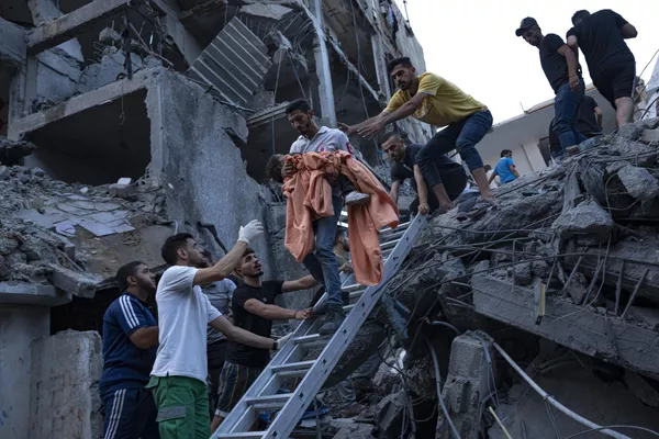 فلسطینی ها کودکی را از زیر آوار یک ساختمان مسکونی ویران شده در پی حمله هوایی اسرائیل نجات دادند.شبه نظامیان حماس در نوار غزه روز شنبه حمله بی سابقه ای را به اسرائیل انجام دادند که در آن بیش از 900 نفر کشته و اسیر شدند. اسرائیل حملات هوایی تلافی جویانه سنگینی را به این منطقه انجام داد و صدها فلسطینی بر اثر این حملات جان خود را از دست دادند. - اسپوتنیک افغانستان  