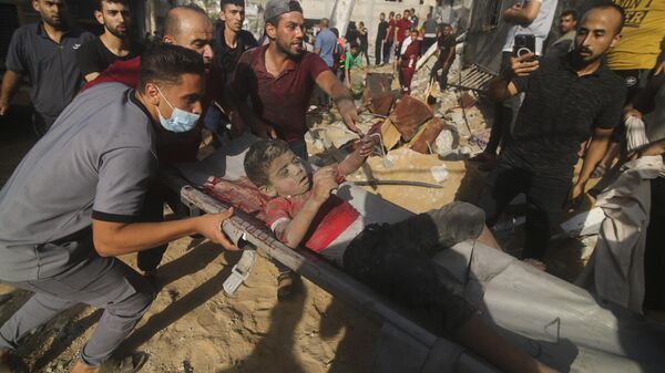 Палестинцы вытаскивают мальчика из-под завалов после удара Израиля по дому семьи Заруб в Рафахе, сектор Газа - اسپوتنیک افغانستان  