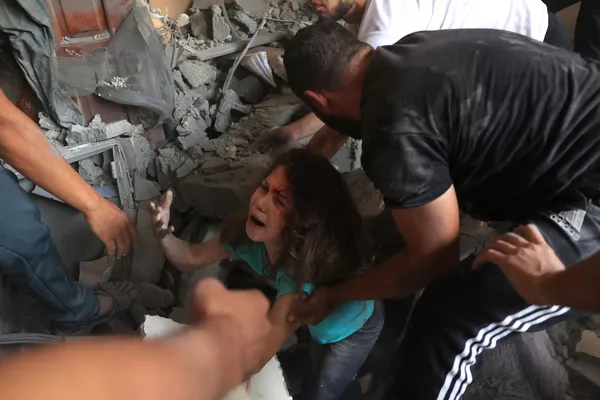فلسطینی ها پس از حمله هوایی اسرائیل به اردوگاه آوارگان رفح در جنوب نوار غزه، دخترکی را از زیر آوار یک ساختمان نجات دادند. - اسپوتنیک افغانستان  