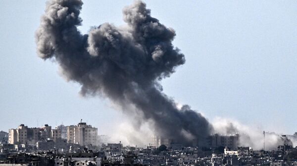 A picture taken from Sderot on October 21, 2023, shows smoke rising over buildings in the Gaza Strip during an Israeli strike, amid the ongoing battles between Israel and the Palestinian group Hamas.  - اسپوتنیک افغانستان  