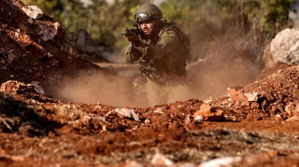 An Israeli army soldier advances during a drill at a position in the upper Galilee region of northern Israel near the border with Lebanon - اسپوتنیک افغانستان  