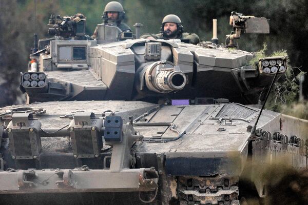 سربازان ارتش اسرائیل در برجک یک تانک جنگی نشسته اند که در موقعیتی در منطقه گالیله بالای شمال اسرائیل در نزدیکی مرز با لبنان در 1 نوامبر 2023 حرکت می کند. - اسپوتنیک افغانستان  
