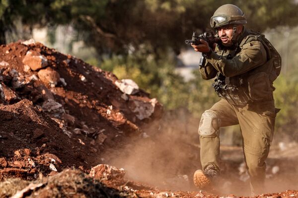 یک سرباز ارتش اسرائیل در حال پیشروی در موقعیتی در منطقه جلیل علیا در شمال اسرائیل در نزدیکی مرز با لبنان است. نوار غزه. - اسپوتنیک افغانستان  