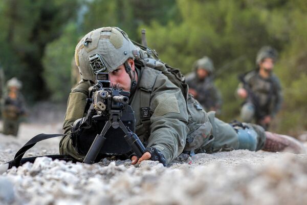 یک سرباز ارتش اسرائیل در حالی که به حالت دراز کشیده در موقعیتی در منطقه جلیل بالایی در شمال اسرائیل در نزدیکی مرز با لبنان در 1 نوامبر 2023. - اسپوتنیک افغانستان  