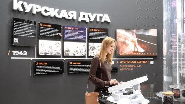 Участница выставки рассматривает стенд на открытии экспозиции на международной выставке-форуме Россия - اسپوتنیک افغانستان  