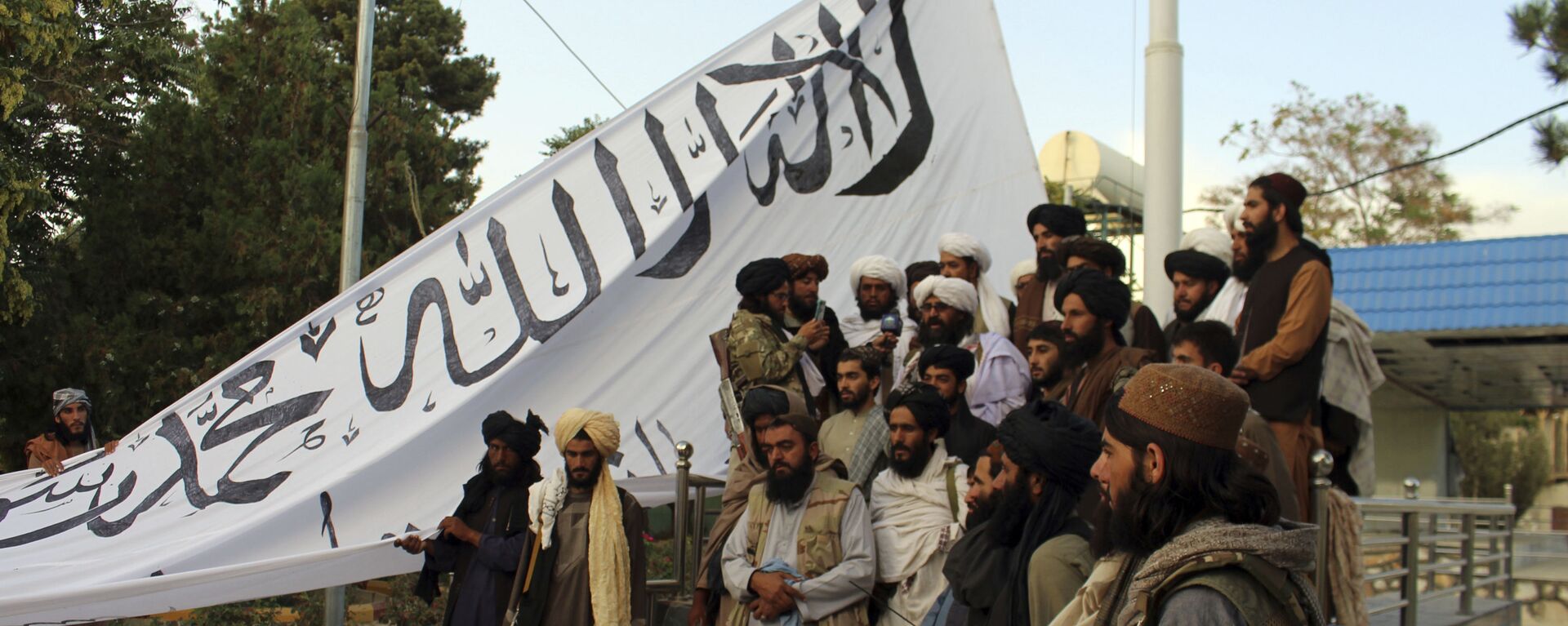 Taliban fighters poses for a photograph while raising their flag Taliban fighters raise their flag at the Ghazni provincial governor's house, in Ghazni, southeastern, Afghanistan, Sunday, Aug. 15, 2021.  - اسپوتنیک افغانستان  , 1920, 06.11.2023