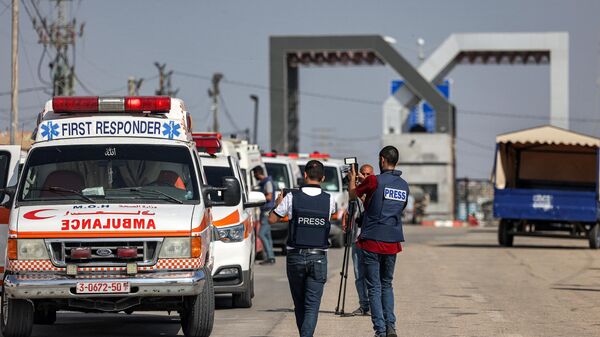 Журналисты снимают, как машины скорой помощи палестинского министерства здравоохранения пересекают переход Рафах на границе сектора Газа и Египта - اسپوتنیک افغانستان  