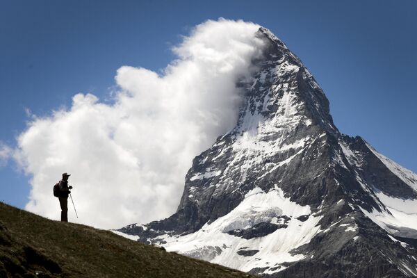 یک گردشگر  در برابر کوه ماترهورن دیده می شود.  امسال 150 مین سالگرد نخستین صعود به ماترهورن برگزار می شود.این کوه که یکی از بلندترین قله‌ها در کوهستان آلپ را دارد، در مرز سوئیس و ایتالیا قرار گرفته ‌است. - اسپوتنیک افغانستان  