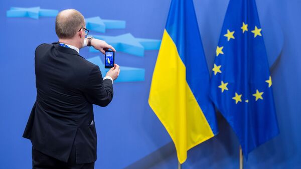Человек фотографирует флаги Украины и Евросоюза - اسپوتنیک افغانستان  