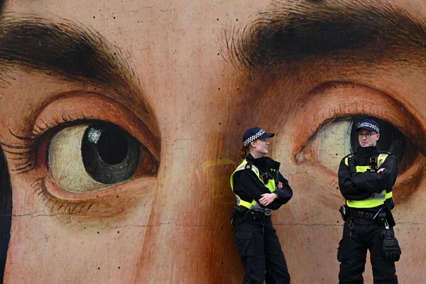 افسران پولیس در مقابل کپی تابلوی &quot;پرتره یک مرد&quot; نقاش ایتالیایی &quot;آنتونلو دا مسینه&quot; پیش از &quot;تظاهرات لندن برای حمایت از فلسطین&quot; در میدان ترافالگار، مرکز لندن صحبت می کنند. 7 اکتبر 2023 - اسپوتنیک افغانستان  