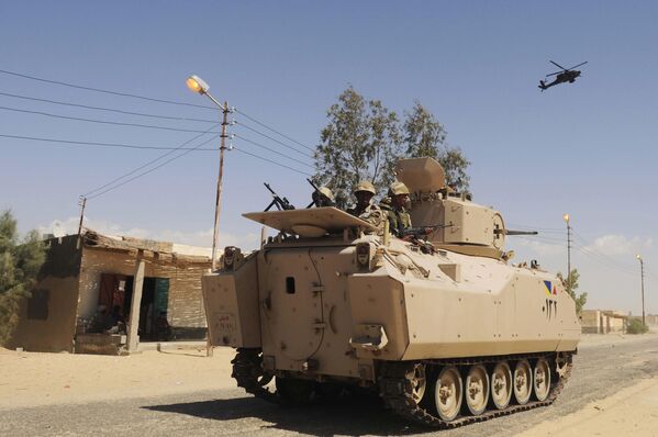 سربازان ارتش مصر در 12 می 2013در حال گشت زنی در یک خودروی زرهی با پشتیبانی یک فروند هلیکوپتر در شمال صحرای سینا هستند. ستیزه جویان اسلامی در آن زمان موجی از حملات همزمان از جمله بمب گذاری انتحاری با خودروهای بمب گذاری شده را علیه ایست های بازرسی ارتش مصر در شمال شبه جزیره سینا به راه انداخته و ده ها سرباز را کشتند. - اسپوتنیک افغانستان  