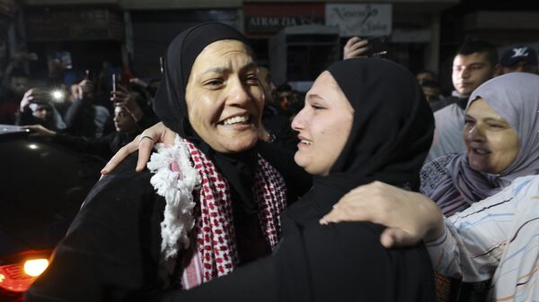 Равда Абу Аджамие обнимает родственницу после освобождения из израильской тюрьмы в рамках соглашения о перемирии между Израилем и ХАМАС - اسپوتنیک افغانستان  