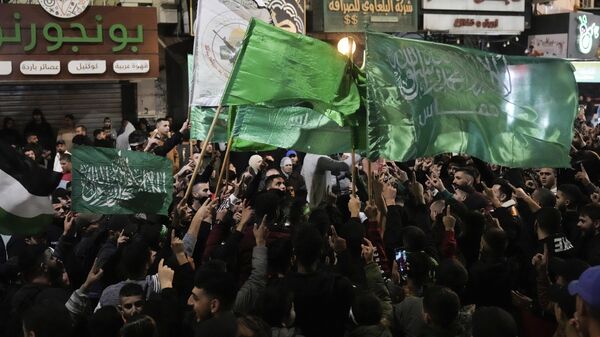 Палестинцы машут флагами ХАМАС, празднуя освобождение Израилем палестинских заключенных в городе Наблус на Западном Берегу - اسپوتنیک افغانستان  