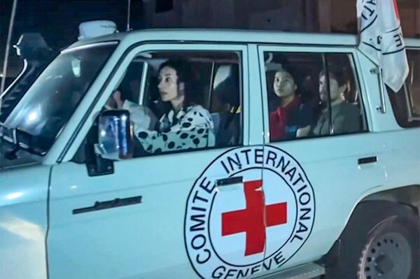 این تصویر که از یک فیلم ویدئویی AFPTV گرفته شده است نشان می‌دهد که یک خودروی صلیب سرخ بین‌المللی حامل گروگان‌های آزاد شده توسط حماس از نقطه مرزی رفح در نوار غزه به سوی مصر می رود و از آنجا به اسرائیل منتقل می‌شود تا در 24 نوامبر 2023 به خانواده‌هایشان ملحق شوند. هر دو طرف گفتند که پس از 48 روز تیراندازی و بمباران که جان هزاران نفر را گرفت، اولین گروگان‌هایی که بر اساس توافق آتش‌بس بین اسرائیل و حماس آزاد شدند، در 24 نوامبر تحویل داده شدند، تقریباً هفت هفته پس از دستگیری. (نگاره از محمود حمص / خبرگزاری فرانسه) - اسپوتنیک افغانستان  