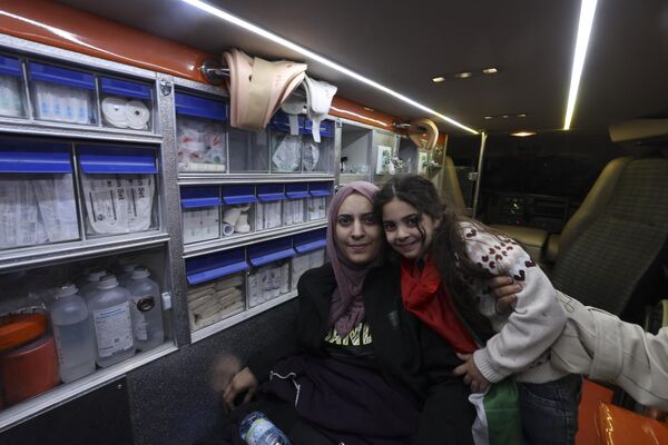 فاطمه شاهین که قادر به راه رفتن نیست، دخترش آیلول را در حالی که پس از آزادی از زندان اسرائیل در داخل آمبولانس نشسته، به عنوان بخشی از توافق آتش بس بین اسرائیل و حماس در اردوگاه آوارگان الدحیشه در کرانه باختری اشغالی بیت لحم، در 24 نومبر 2023 در آغوش می گیرد. هر دو طرف گفتند که پس از 48 روز تیراندازی و بمباران که هزاران کشته بر جای گذاشت، اولین گروگان‌هایی که بر اساس توافق آتش‌بس بین اسرائیل و حماس آزاد شدند، در 24 نوامبر تحویل داده شدند، تقریباً هفت هفته پس از دستگیری. (نگاره از حازم بادر / خبرگزاری فرانسه) - اسپوتنیک افغانستان  