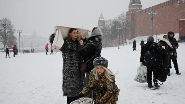 Женщины готовятся позировать для фотосессии на заснеженной Красной площади в Москве - اسپوتنیک افغانستان  