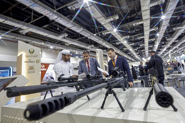 بازدیدکنندگان در روز گشایش سومین دوره نمایشگاه دفاع مصر (ایدکس-2023) در کنار تفنگ های تک تیرانداز ایستاده اند. - اسپوتنیک افغانستان  
