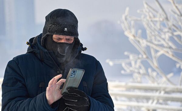 یک رهگذر با تلفن همراه در مرکز کراسنویارسک در دمای هوای حدود 27 درجه سانتیگراد زیر صفر. در طول روز، دمای هوا در کراسنویارسک به زیر 30 درجه زیر صفر و در مناطق مرکزی و جنوبی منطقه به 40 درجه زیر صفر کاهش یافت. - اسپوتنیک افغانستان  