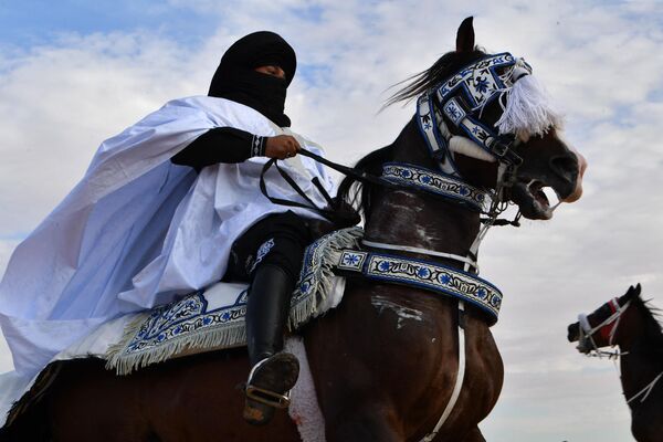 یک مجری با لباس سنتی در حین نمایش در آغاز جشنواره بین المللی صحرا در دوز، در جنوب تونس، سوار بر اسب می شود. 27 دسامبر 2023 - اسپوتنیک افغانستان  