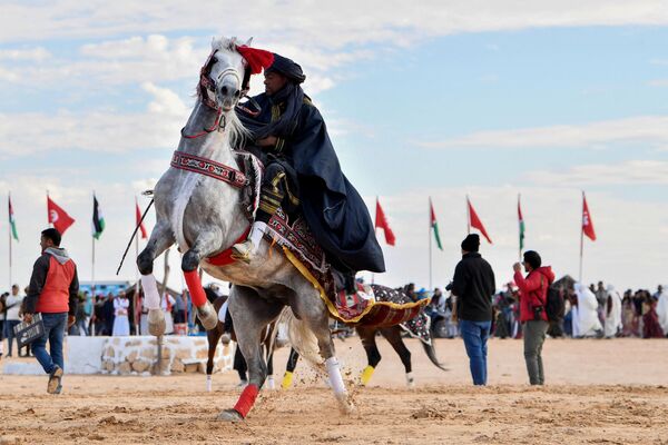 یک مجری با لباس سنتی در آغاز جشنواره بین المللی صحرا  در دوز، در جنوب تونس، سوار بر اسب می شود. 27 دسامبر 2023 - اسپوتنیک افغانستان  
