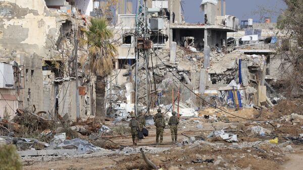 Израильские военнослужащие проходят мимо разрушенных зданий по дороге Салахеддин, которая соединяет север сектора Газа с югом, в районе Зейтун на окраине города Газа - اسپوتنیک افغانستان  